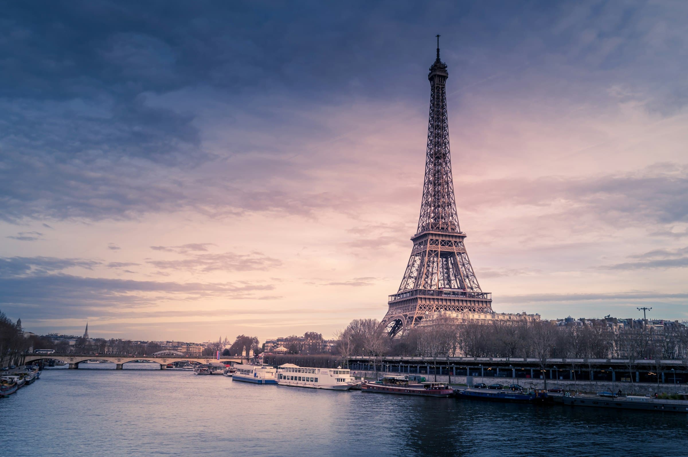 The Eiffel Tower over the Seine river in Paris at dusk
