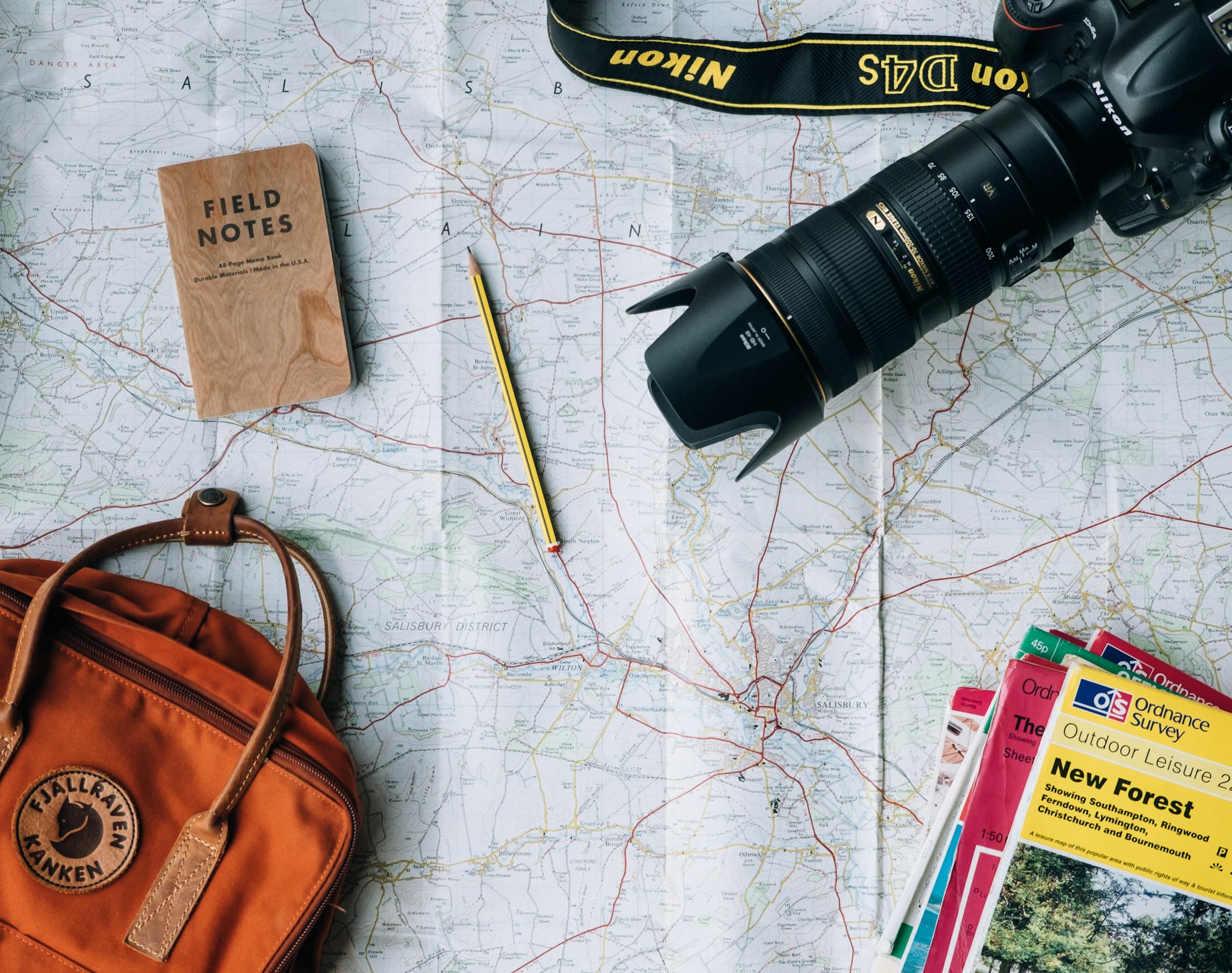 A travel map laid out with a backpack, camera, and guidebooks ready for a trip